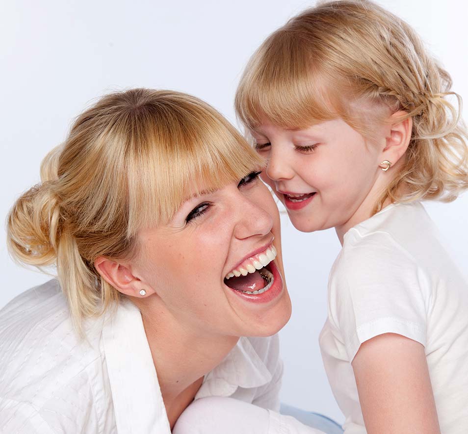 Mum with lingual braces smiling happily with her daughter